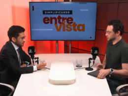 Kim Kataguiri participa de entrevista no programa Simplificando, da DiaTV, conduzida por Gui Sampaio. O deputado federal aparece à esquerda, de terno e gravata, enquanto o apresentador está à direita, em frente aos microfones, em um estúdio com iluminação vermelha e um monitor ao fundo exibindo a identidade visual do programa "Simplificando Entrevista".