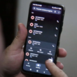 Homem mechendo no celular enquanto se depara com ligação de spam