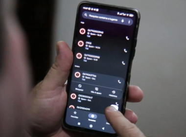 Homem mechendo no celular enquanto se depara com ligação de spam